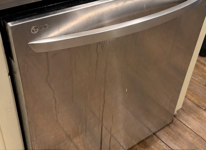 Before cleaning: a stainless steel dishwasher front with streaks